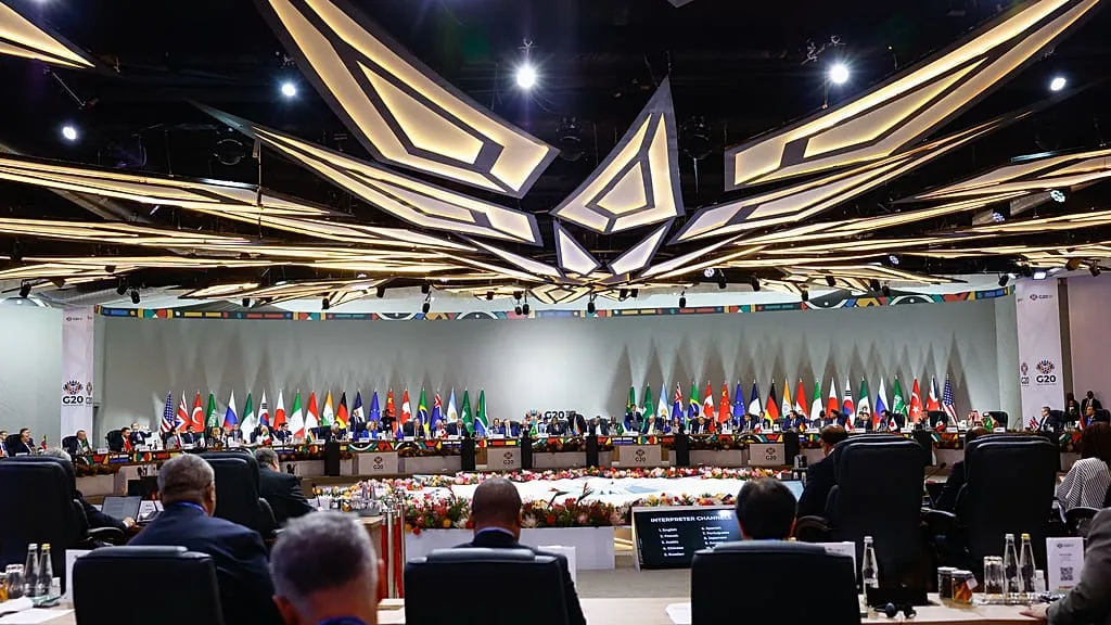Wide shot of G20 leaders at the Johannesburg summit with flags in background