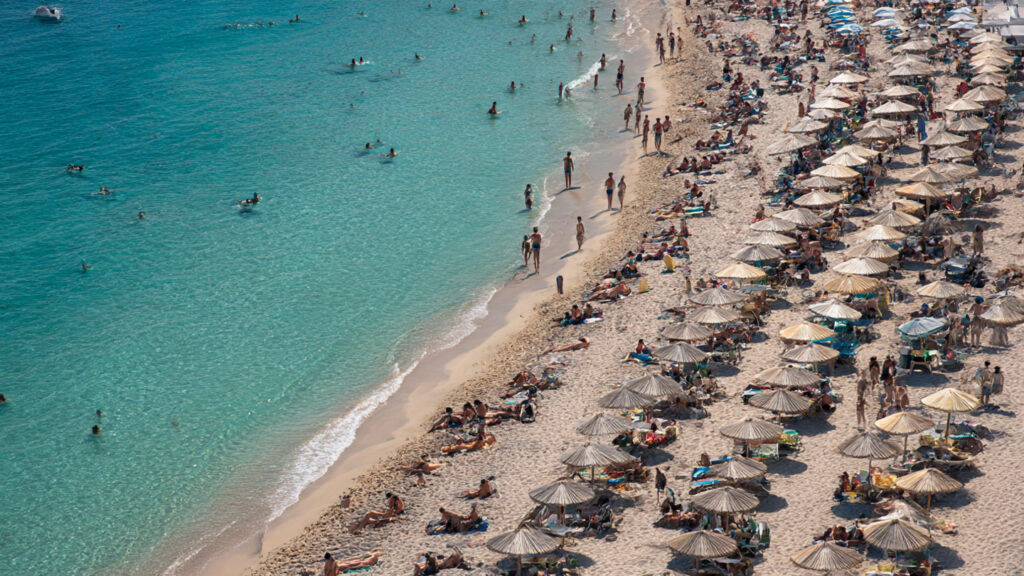 Crowded beach in Greece showing the rise in Greek Islands Tourism 2025
