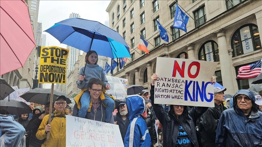 Protesters holding “No King” signs in a rally defending democracy and free speech.